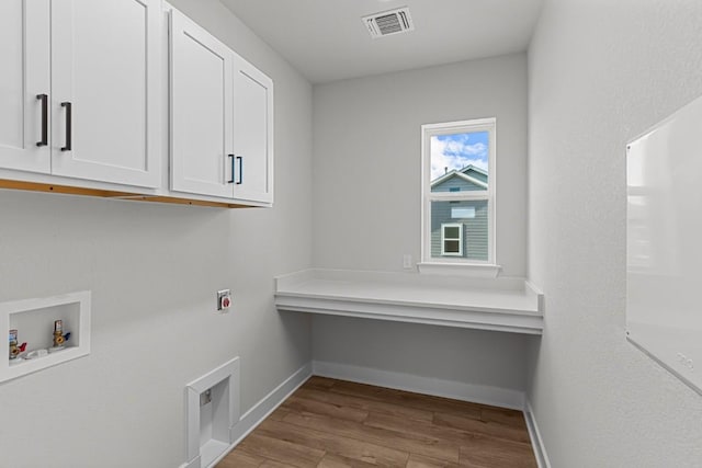 clothes washing area with cabinets, washer hookup, light wood-type flooring, and hookup for an electric dryer