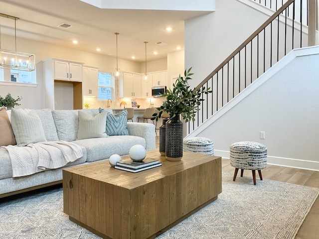 living room with a notable chandelier and light hardwood / wood-style flooring