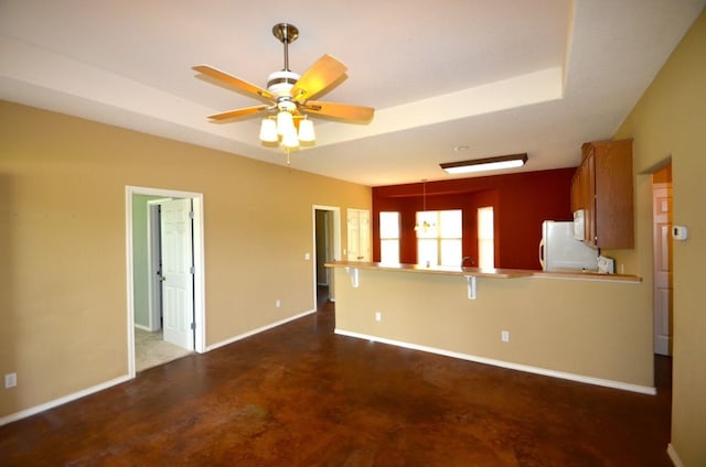 interior space with a tray ceiling and ceiling fan