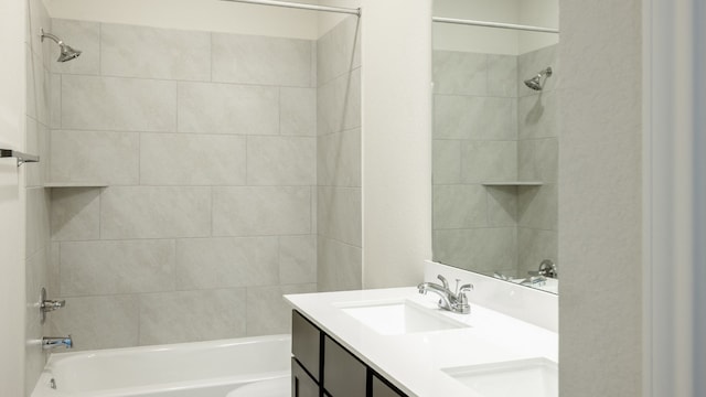 bathroom featuring vanity and tiled shower / bath