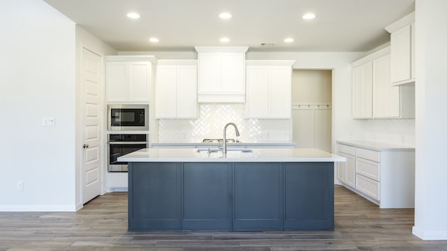 kitchen featuring appliances with stainless steel finishes, sink, an island with sink, and white cabinets