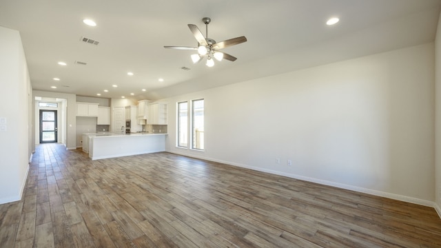 unfurnished living room with ceiling fan and light wood-type flooring