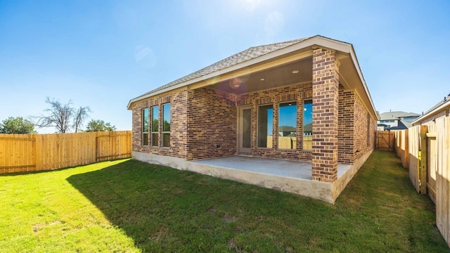 rear view of property featuring a patio and a lawn