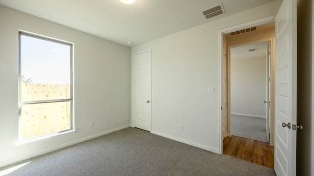 unfurnished bedroom with carpet floors and multiple windows