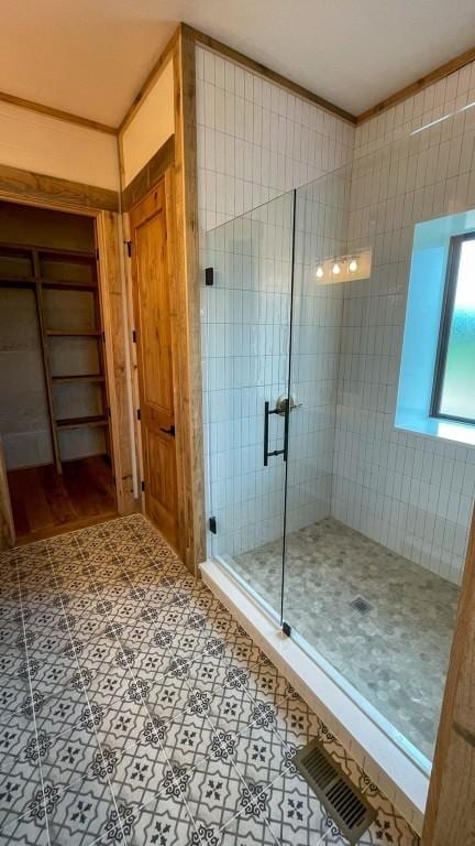 bathroom featuring tile patterned floors, walk in shower, and crown molding