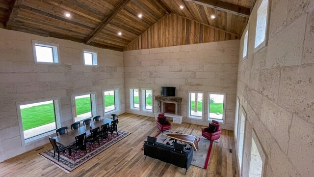 living room featuring light hardwood / wood-style floors, wood ceiling, beam ceiling, and high vaulted ceiling