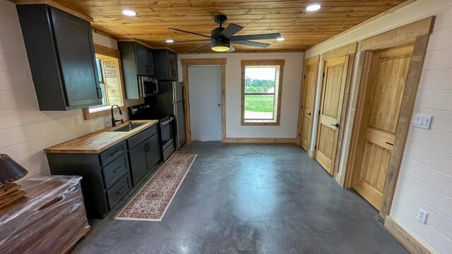 kitchen with wood counters, appliances with stainless steel finishes, ceiling fan, sink, and wooden ceiling