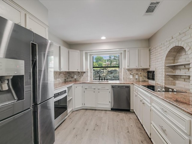 kitchen with black appliances, a sink, visible vents, and white cabinets