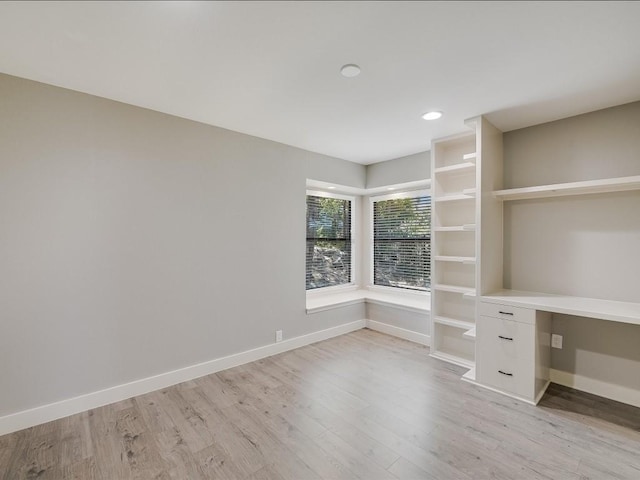 unfurnished office with recessed lighting, baseboards, built in study area, and light wood finished floors