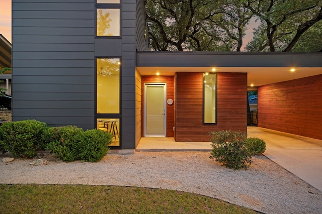 exterior entry at dusk featuring a carport