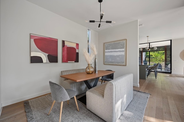 dining area with hardwood / wood-style floors and a notable chandelier