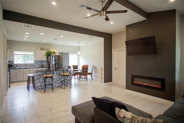 living room featuring a wealth of natural light and ceiling fan