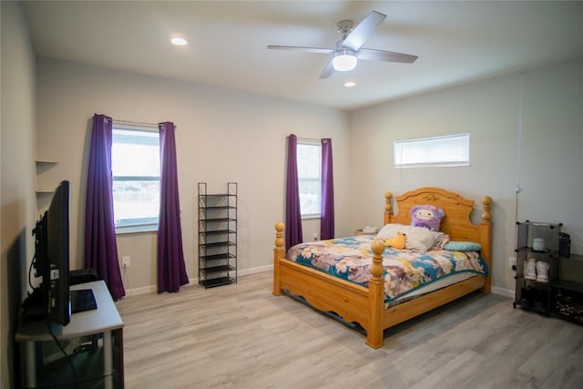 bedroom with multiple windows, ceiling fan, and light hardwood / wood-style flooring