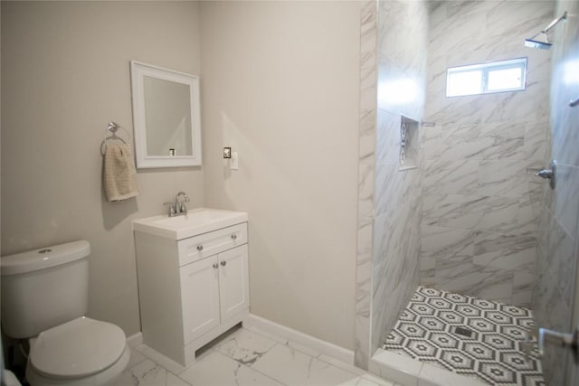 bathroom with toilet, vanity, and tiled shower