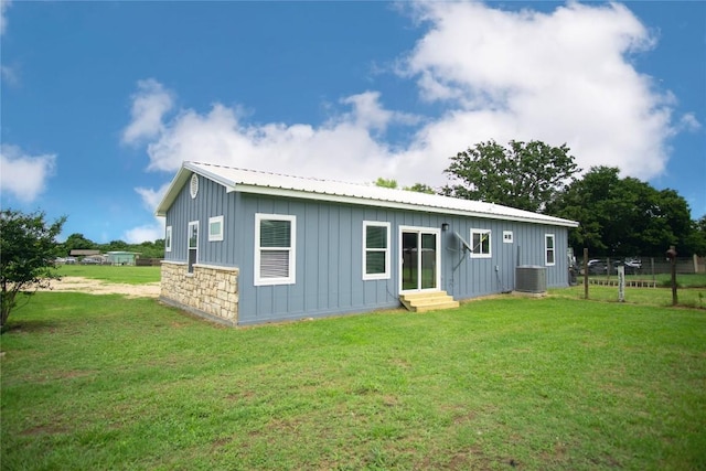 rear view of property with a yard and central AC unit