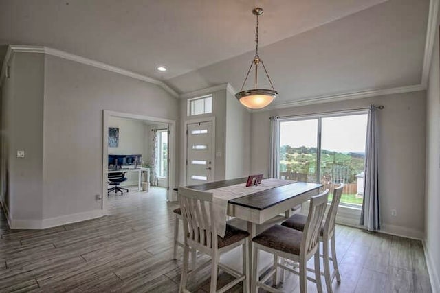 dining area with wood-type flooring, lofted ceiling, and ornamental molding