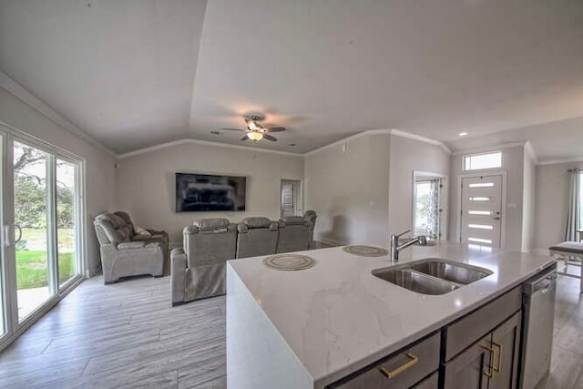 kitchen featuring dishwasher, a kitchen island with sink, sink, and light hardwood / wood-style flooring