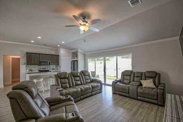 living room with light wood-type flooring, vaulted ceiling, ceiling fan, and crown molding