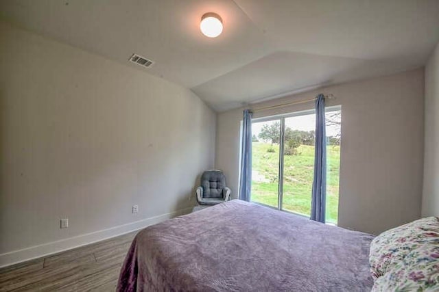 bedroom with hardwood / wood-style floors and vaulted ceiling