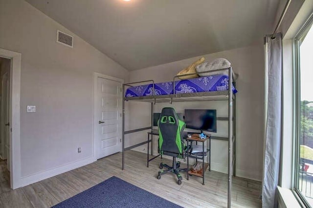 bedroom with wood-type flooring and vaulted ceiling