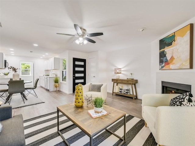 living room with light wood-type flooring and ceiling fan