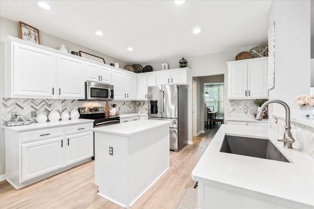 kitchen featuring white cabinets, decorative backsplash, stainless steel appliances, and sink