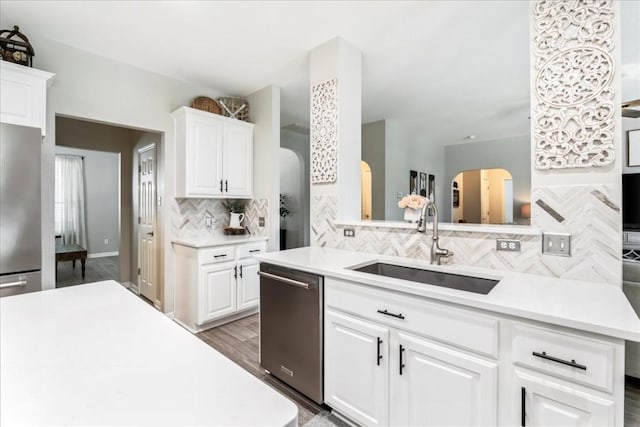 kitchen featuring white cabinets, backsplash, stainless steel appliances, and sink