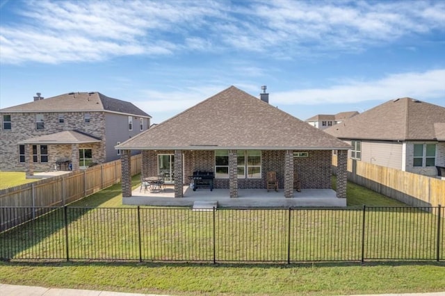 rear view of house featuring a patio area and a lawn