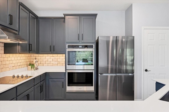 kitchen featuring decorative backsplash, gray cabinets, and stainless steel appliances