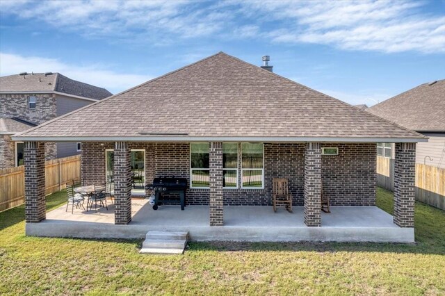 rear view of house featuring a lawn and a patio