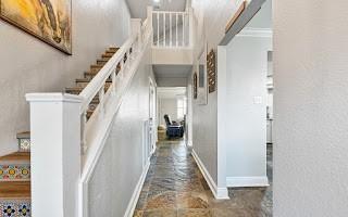 corridor with ornamental molding and dark tile flooring