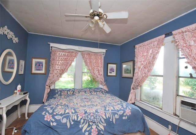 bedroom with hardwood / wood-style floors, ceiling fan, and multiple windows