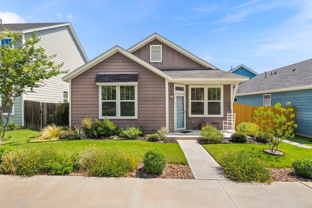 view of front of home featuring fence, board and batten siding, and a front yard