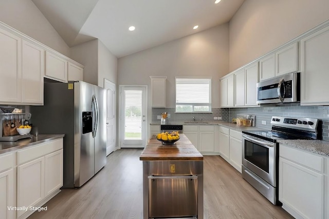 kitchen with white cabinets, sink, stainless steel appliances, and wooden counters