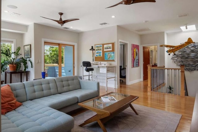 living room with light hardwood / wood-style flooring, a wealth of natural light, and ceiling fan