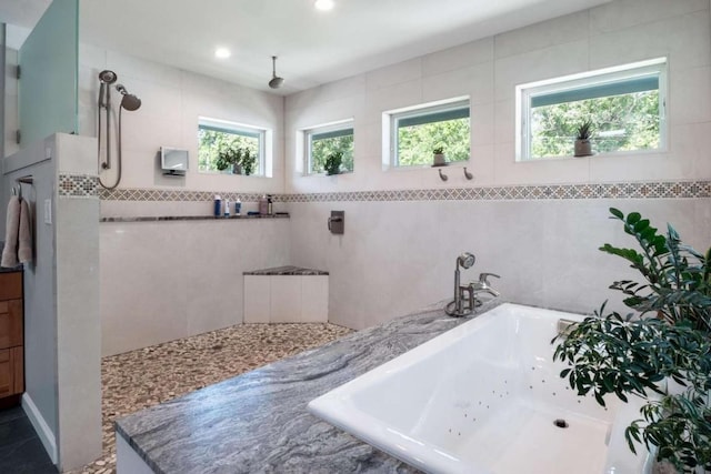 bathroom with tile patterned floors, sink, tile walls, and shower with separate bathtub