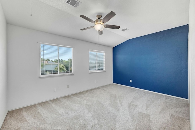 carpeted empty room with lofted ceiling and ceiling fan