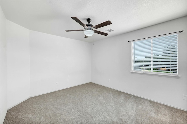 unfurnished room with ceiling fan, a textured ceiling, and carpet