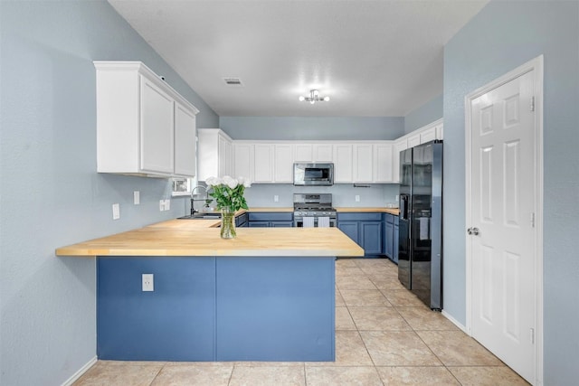 kitchen with blue cabinets, white cabinetry, appliances with stainless steel finishes, and kitchen peninsula