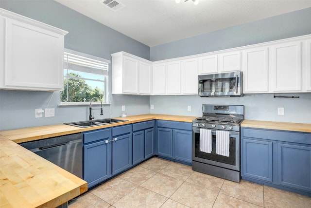 kitchen featuring butcher block countertops, white cabinetry, and appliances with stainless steel finishes