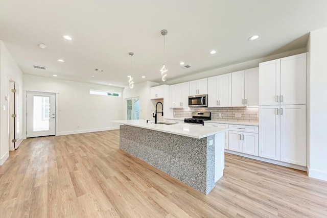 kitchen featuring white cabinets, stainless steel appliances, and light hardwood / wood-style flooring