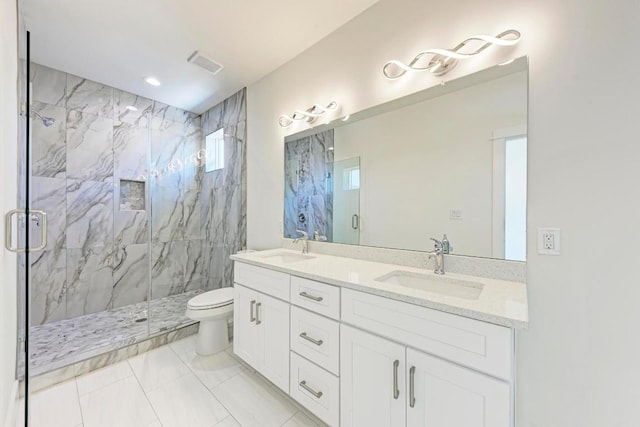 bathroom with tile patterned floors, vanity, a shower with shower door, and toilet