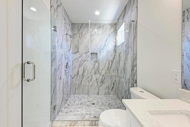 bathroom with vanity, toilet, and a shower with shower door