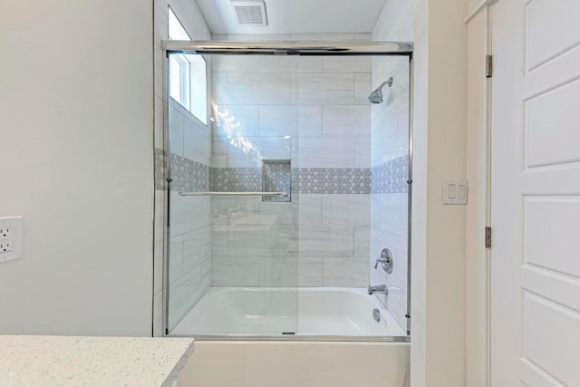 bathroom with bath / shower combo with glass door