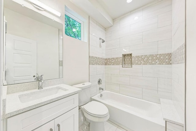 full bathroom featuring vanity, tiled shower / bath combo, and toilet