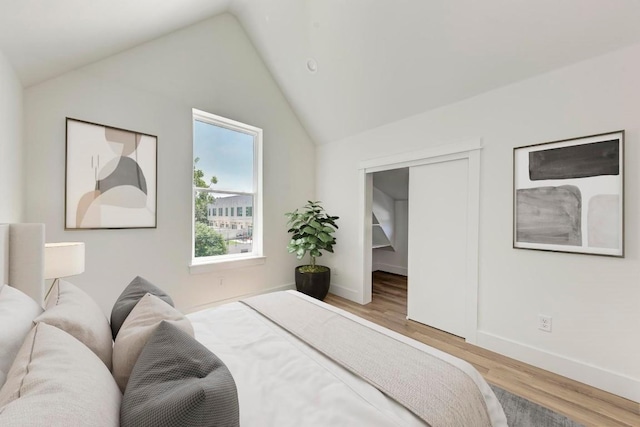 bedroom with vaulted ceiling and hardwood / wood-style flooring