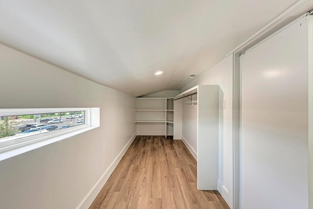 walk in closet featuring light wood-type flooring and lofted ceiling