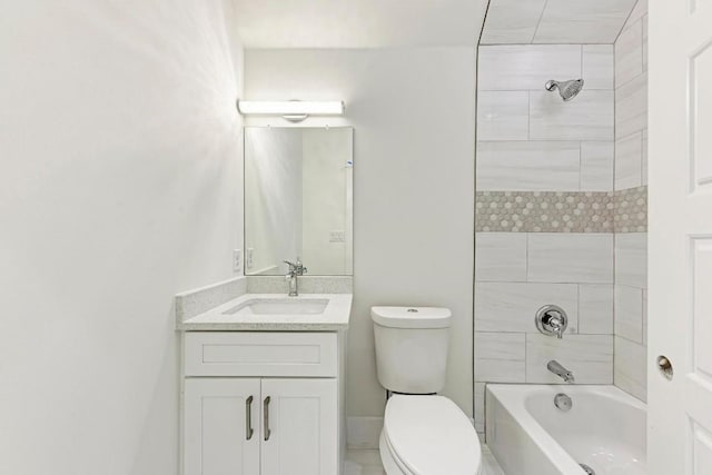 full bathroom featuring tiled shower / bath combo, toilet, and vanity