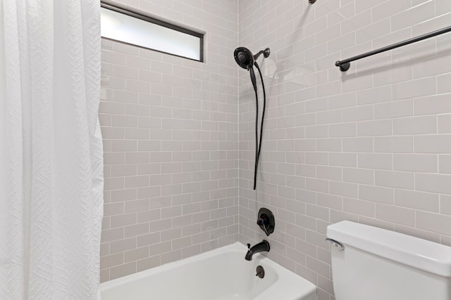 bathroom featuring shower / bathtub combination with curtain and toilet