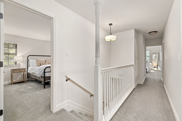 hallway featuring plenty of natural light and light colored carpet